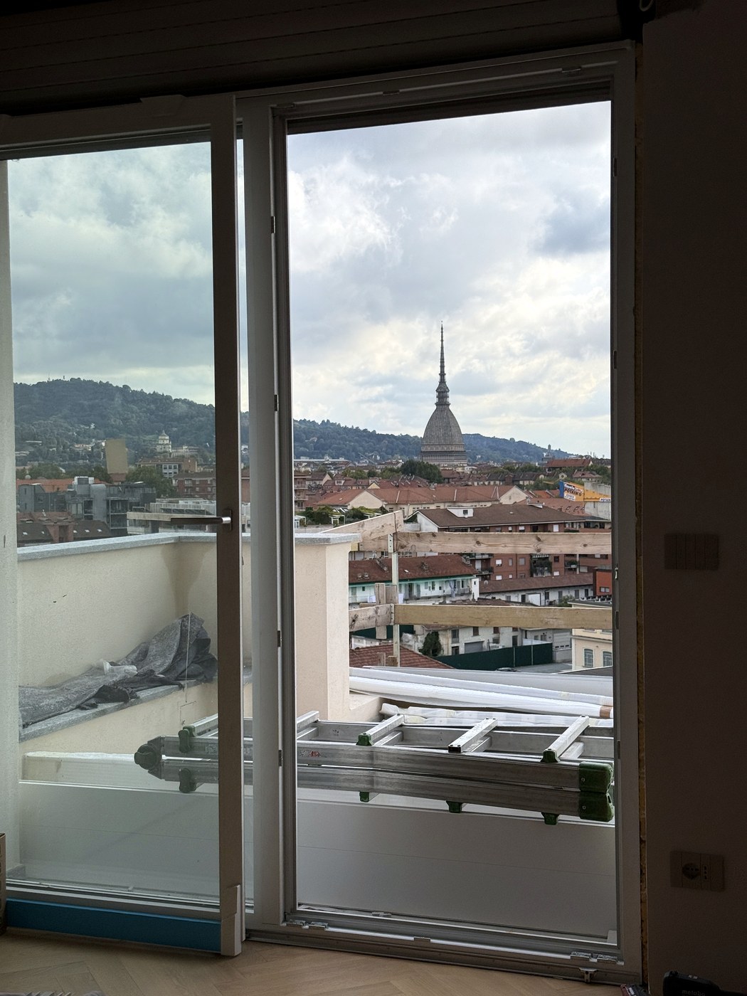 Portafinestra affacciata sulla Mole, in un cantiere con parapetti, blindate e serramenti